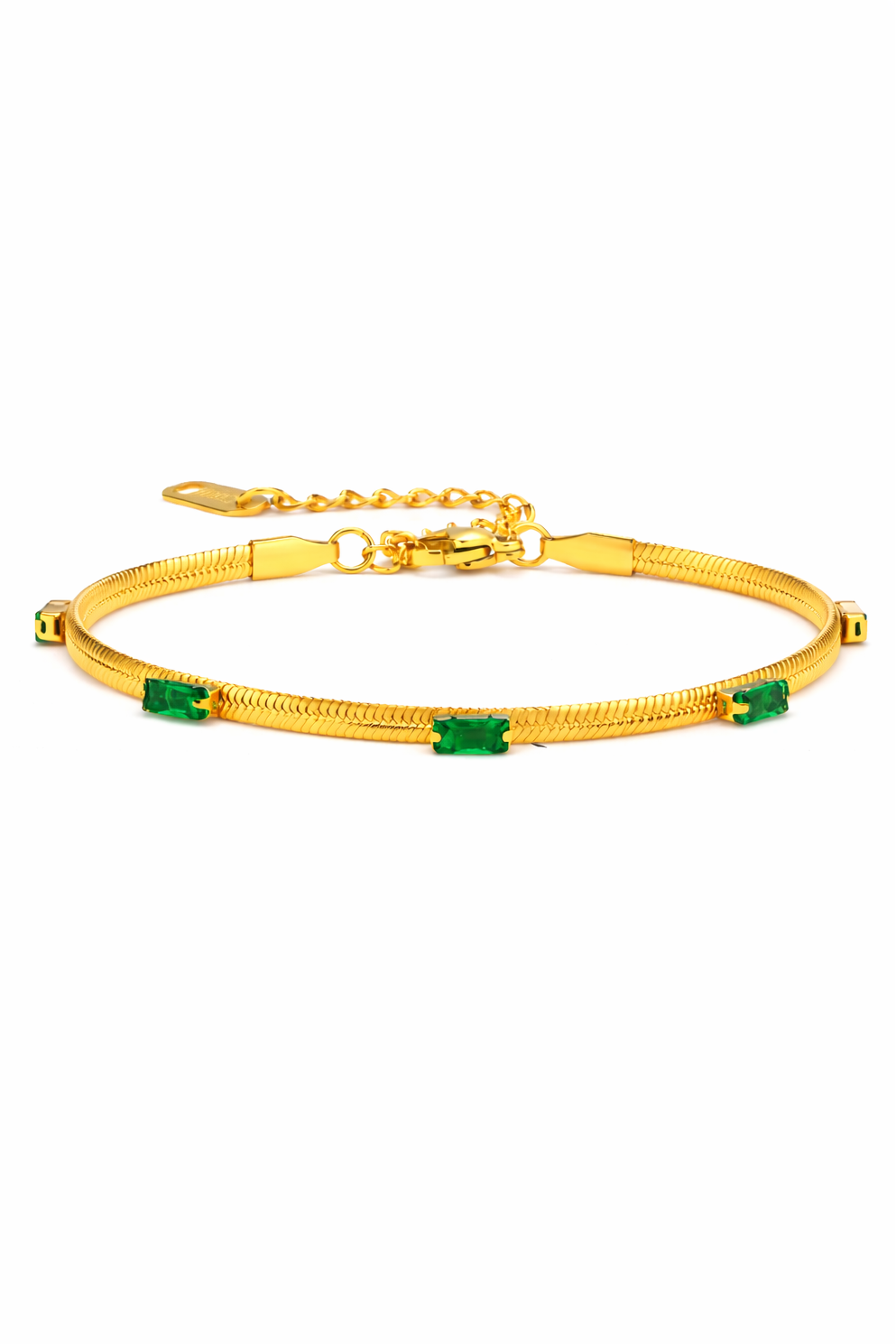 Gold snake chain bracelet with emerald-green rectangular stones and adjustable clasp on a soft neutral background